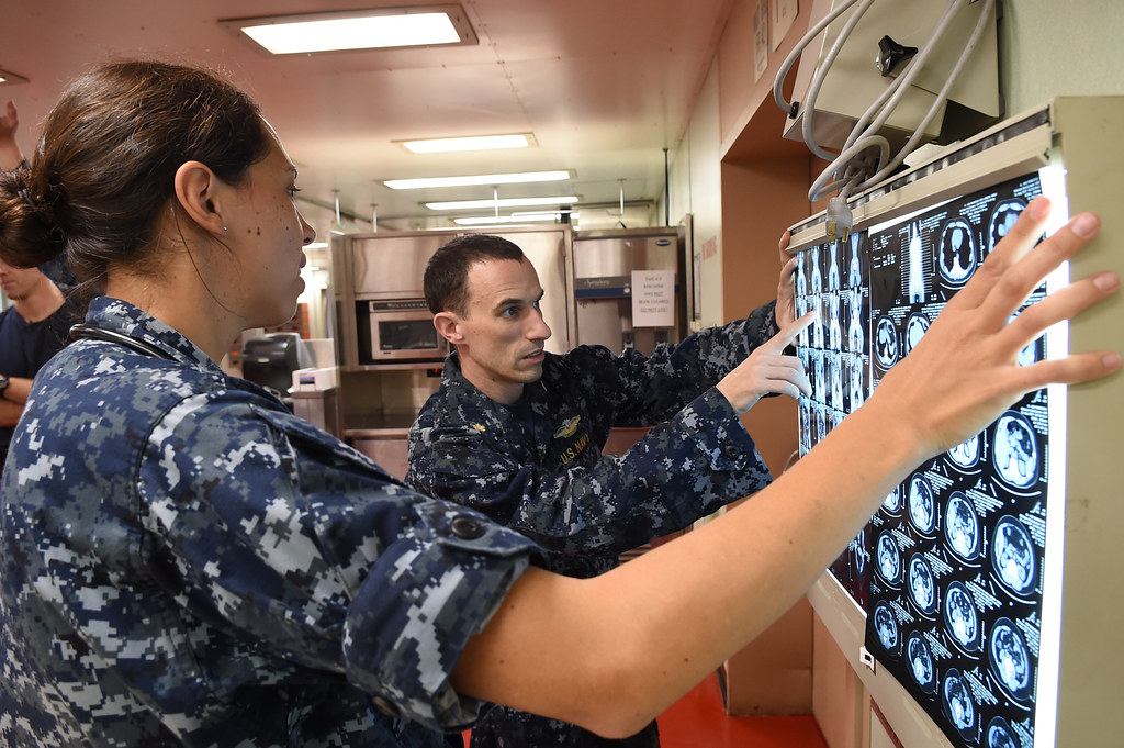 Sailors review CT scans of a patient from Centro Medico in San Juan aboard USNS Comfort.
